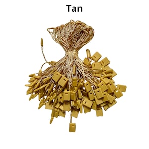 May include: A bundle of tan string with small, square plastic tags attached. The string is twisted and the tags are clustered together.