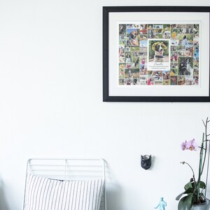 May include: A black framed photo collage of a dog with the name "Camille" written below the image. The collage is hanging on a white wall above a white metal bed frame with a striped pillow.