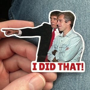 Op de afbeelding: Een witte sticker met twee mannen, waarvan &eacute;&eacute;n wijst, met de tekst "I DID THAT!" in het rood. De sticker wordt in een hand gehouden tegen een denim achtergrond.