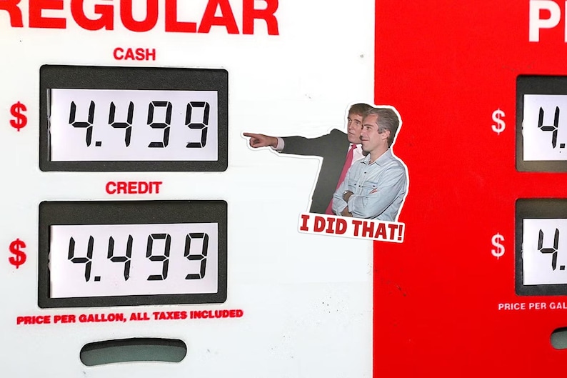 Op de afbeelding: Een benzinepompdisplay met prijzen van $4,499 per gallon voor contant en credit. Een sticker met twee mannen en de tekst "I DID THAT!" is op de pomp geplaatst. Het woord "REGULAR" is bovenaan zichtbaar.