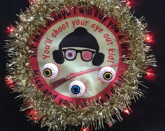 Ugly Christmas sweater. “You’ll shoot your eye out” from the classic movie “A Christmas Story”. 3 eyeballs to try and hit the bullseye!