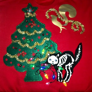 ugly christmas sweater front and back lighted cat chewing on christmas lights thus fried cat on the back, flying squirrel  into the tree