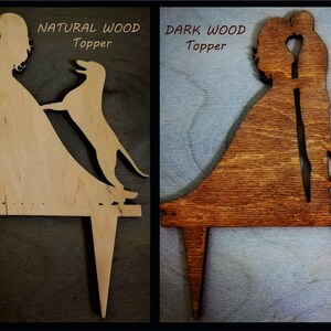 May include: Two wooden cake toppers depicting a bride and groom kissing. The topper on the left is made of natural wood and features a dog. The topper on the right is made of dark wood and features a cat. Both toppers have the text "Topper" on them.