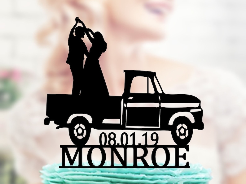 May include: Black silhouette of a couple dancing in the back of a black pickup truck. The truck has a white bed and a white stripe along the side. The date 08.01.19 and the name MONROE are written below the truck.