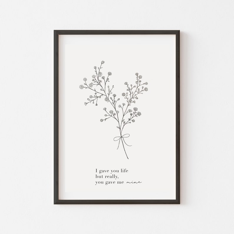 Peut inclure: Impression en noir et blanc d'un bouquet de petites fleurs avec un ruban nou&eacute; autour des tiges. L'impression comprend le texte "I gave you life but really, you gave me mine."