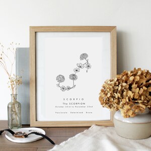 May include: A framed print featuring a black and white line drawing of the Scorpio constellation, formed from stylised flowers. The text "Scorpio, The Scorpion, October 23rd to November 22nd, Passionate, Determined, Brave" is printed beneath the drawing.