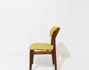 May include: A wooden chair with a medium brown finish and a mustard yellow upholstered seat and backrest. The chair features four straight legs and a curved back support, shown from a side profile against a plain white background.