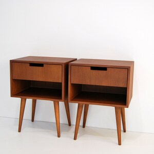 May include: Two wooden bedside tables with drawers and shelves. The tables are brown and have four legs.
