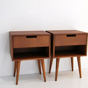 May include: Two wooden nightstands with a single drawer and a lower shelf. Each nightstand has four tapered legs.