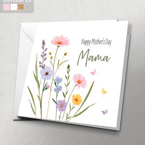 May include: A white Mother's Day card with a watercolor floral design. The card features pink, purple, yellow, and blue flowers, green stems, and butterflies. The words "Happy Mother's Day Mama" are written on the front.