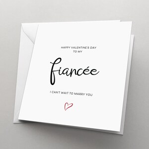 May include: White card with black text that reads "Happy Valentine's Day to my fiancée. I can't wait to marry you." A small red heart is drawn at the bottom of the card.