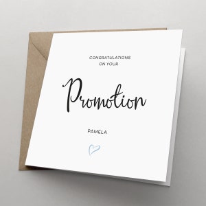 May include: A white card with black text that reads "Congratulations on your Promotion" and "Pamela". A light blue heart is drawn below the text.