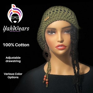 May include: A green crocheted beanie with an adjustable drawstring. The beanie has a small gold tag with the word "Yah!" on it. The beanie is being worn by a mannequin with long black braids.