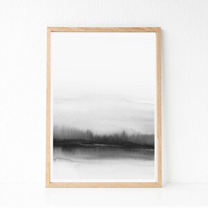 May include: A black and white watercolor painting of a landscape with a horizon line and a dark foreground. The painting is framed in a light wood frame.