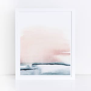 May include: Abstract watercolor painting in a white frame. The painting features a soft pink and blue color scheme with a horizontal line separating the two colors.