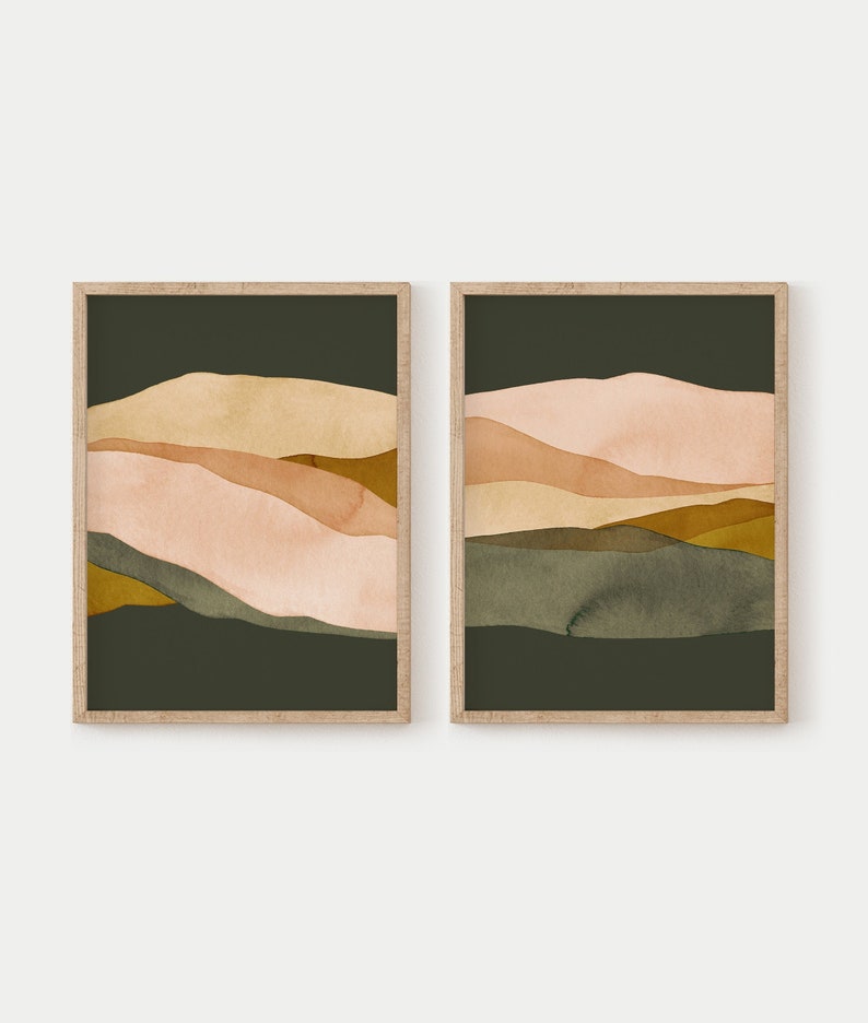 May include: Two framed abstract landscape prints with a dark green background and layered shapes in shades of pink, brown, and yellow.