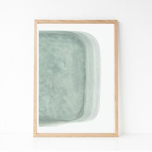 May include: A framed abstract art print with a light green watercolor design. The design features a series of overlapping rounded shapes.