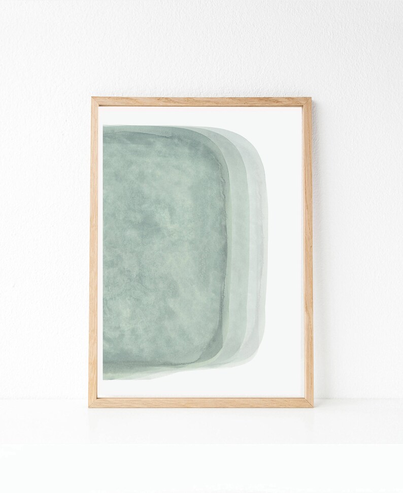 May include: A framed abstract art print with a light green watercolor design. The design features a series of overlapping rounded shapes.