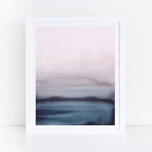 May include: Abstract watercolour painting in a white frame. The painting features a gradient of pink, purple, and blue colours, creating a hazy, atmospheric effect.