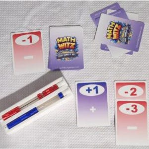 May include: A Math Witz card game set featuring a deck of cards with purple and white gradients, red cards labeled -1, -2, and -3, and a purple card labeled +1. A white plastic tray holds two clear plastic pens with red and blue accents.