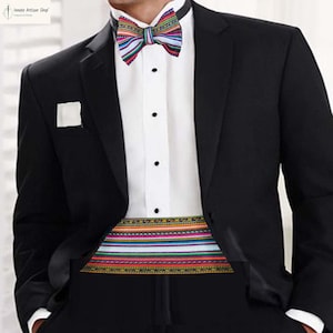 May include: A black tuxedo jacket with a white dress shirt, a colorful striped bow tie, and a matching cummerbund. The bow tie and cummerbund feature a vibrant pattern of red, blue, green, and yellow stripes. A white pocket square is visible.