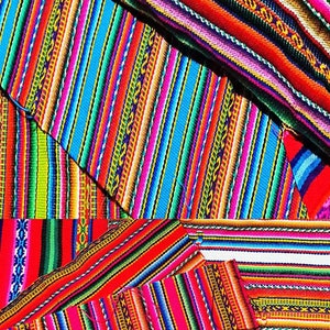 Könnte beinhalten: Bunt gestreiftes Stoffgewebe mit verschiedenen Mustern und Farben, darunter Rot, Blau, Grün, Gelb und Weiß.