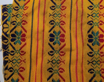 May include: A rectangular piece of yellow fabric measuring 16 inches wide by 24 inches long. The textile features vertical stripes in red, dark blue, and teal, interspersed with repeating geometric floral patterns in the same colors.