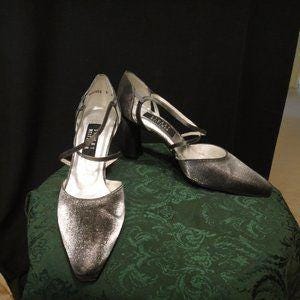 May include: A pair of silver sparkly heels with a strap across the foot and a pointed toe.