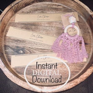 Könnte beinhalten: Ein rosa-weißer Auto-Anhänger mit einem Holzring und einem Quasten. Der Anhänger liegt auf einem Holztablett mit dem Text "Car Charm" und "Sofortiger digitaler Download".