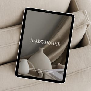 May include: A tablet computer displaying a website with the text "HAUS&HOMME" and the tagline "Where house and home meet, there can always be laughter and special moments shared between family and friends."