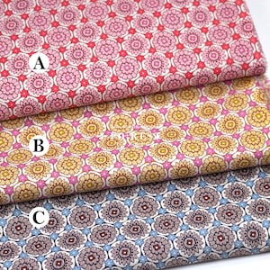 May include: Three fabric swatches with floral patterns. The top swatch is pink with red and white accents. The middle swatch is yellow and pink. The bottom swatch is blue and brown. The fabrics are likely cotton or linen.
