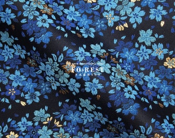 May include: Blue and gold floral brocade fabric with a repeating pattern of small flowers. The fabric has a subtle sheen and a luxurious feel.