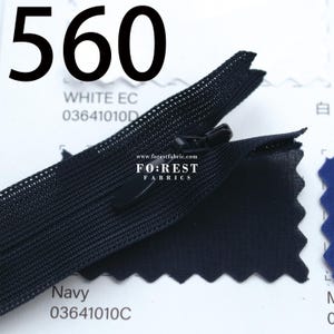 May include: A close-up of a black zipper with a matching pull tab. The image includes the text "560", "WHITE EC", "Navy", and "FO:REST FABRICS". The zipper is set against a white and navy blue background.