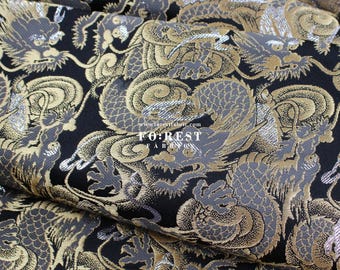 May include: Black fabric with a repeating pattern of gold and silver dragons. The fabric has a textured, woven look. The text "FOREST FABRICS" is visible in the lower center of the image.