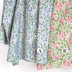 Puede incluir: Dos muestras de tela floral. Una presenta un patrón de flores azules y blancas con hojas verdes sobre un fondo blanco. La otra tiene flores rosas y hojas verdes sobre un fondo blanco. Las telas están etiquetadas A y B.