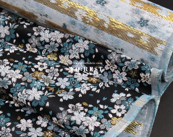 May include: Two rolls of fabric with a floral pattern. The top roll is light blue with gold stripes. The bottom roll is black with teal and silver flowers. The text "www.forestfabric.com" is visible on the fabric.