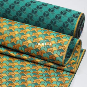 May include: Two rolls of fabric with geometric patterns. The top roll has a teal and dark green pattern. The bottom roll has a teal, orange, and gold pattern. The text "FOREST FABRICS" is visible on the bottom roll.