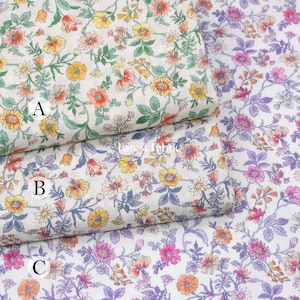 May include: Three fabric swatches with floral patterns. Swatch A features yellow, orange, and pink flowers with green leaves on a white background. Swatch B has similar colors with blue accents. Swatch C has pink and purple flowers.