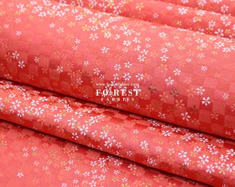 May include: Red fabric with a white and gold floral pattern. The fabric has a checkered pattern and is folded in thirds. The text "FOREST FABRICS" is visible in the centre of the image.