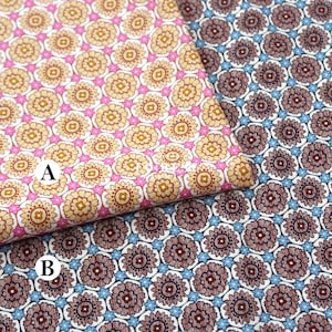 May include: Two fabric swatches with floral patterns. One features a repeating pattern of yellow and pink flowers on a white background. The other has a pattern of brown flowers with blue accents on a white background.