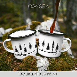 May include: Two white enamel mugs with black rims and a black forest silhouette design. One mug says "Melanie & Tom" and the other says "09.10.21".