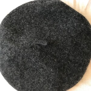May include: A dark gray wool beret.