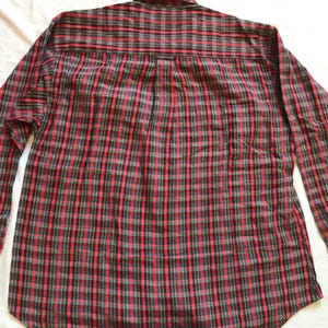Puede incluir: Camisa de manga larga a cuadros rojos, negros y grises. La camisa tiene un dise&ntilde;o cl&aacute;sico con botones, cuello y pu&ntilde;os. El estampado de cuadros es un dise&ntilde;o tradicional, adecuado para ropa informal.