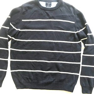 Puede incluir: Un suéter azul marino y blanco a rayas con cuello redondo. El suéter tiene el nombre de la marca "Hackett" en la etiqueta.