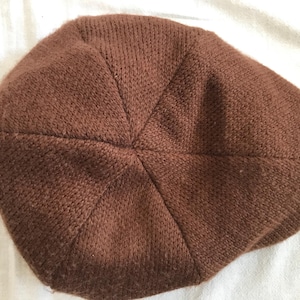 May include: A brown knitted beanie hat with a soft, fuzzy texture.