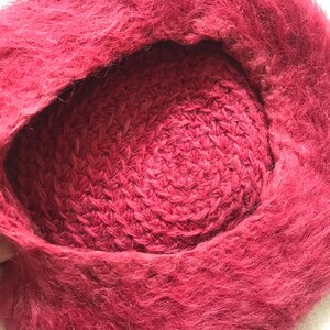 May include: A deep red fuzzy hat with a crocheted lining. The hat is made of a soft, fluffy material.