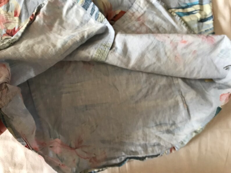 May include: A light blue cotton shirt with a floral print. The shirt is turned inside out, showing the lining.