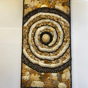 Mosaico de conchas. En su mayoría conchas que recogí y aplasté conchas encontradas en la playa con cuentas de semillas en madera reciclada.
