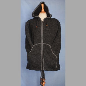 Peut inclure: Veste à capuche gris foncé avec fermeture éclair intégrale et deux poches avant. La veste a une capuche noire et une bordure grise. La capuche a des cordons orange. La veste est présentée sur un mannequin.