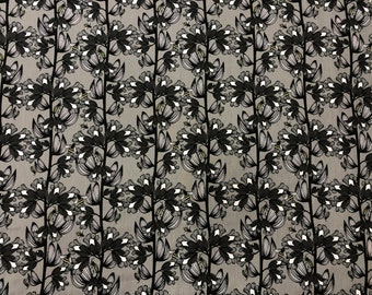 Puede incluir: Una tela gris con un patrón floral en blanco y negro. El patrón presenta flores y abejas estilizadas.